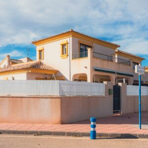 a house with a fence and a blue pole in front of it